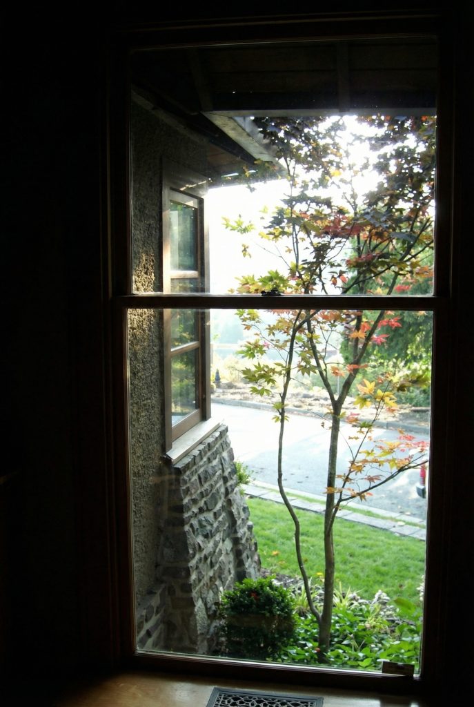 Entry hallway of Charles S. Greene House showing textured plaster walls and natural wood architectural elements