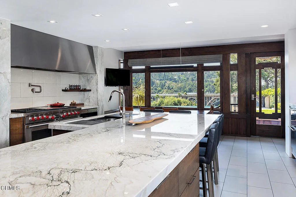 Kitchen of the Laurabelle A. Robinson House with white cabinetry, marble countertops, professional range, and center island