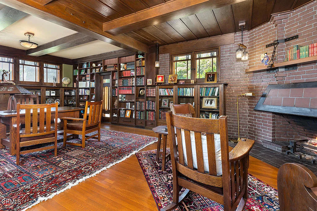 Den in the Laurabelle A. Robinson House with built-in bookshelves, wood paneling, fireplace, and Arts and Crafts details