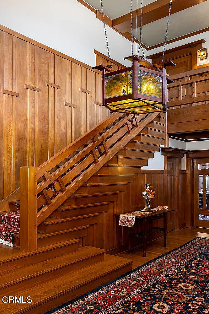 Main stairway of the Laurabelle A. Robinson House with wood balustrade, Arts and Crafts details, and natural lighting