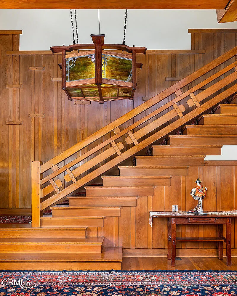Grand stairway of the Laurabelle A. Robinson House with carved wood balustrade, newel posts, and Arts and Crafts joinery