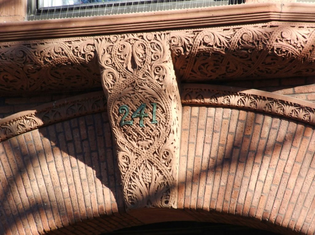 Detailed view of ornate terracotta architectural ornament with Chinese motifs on the Pratt Brooklyn residence facade.