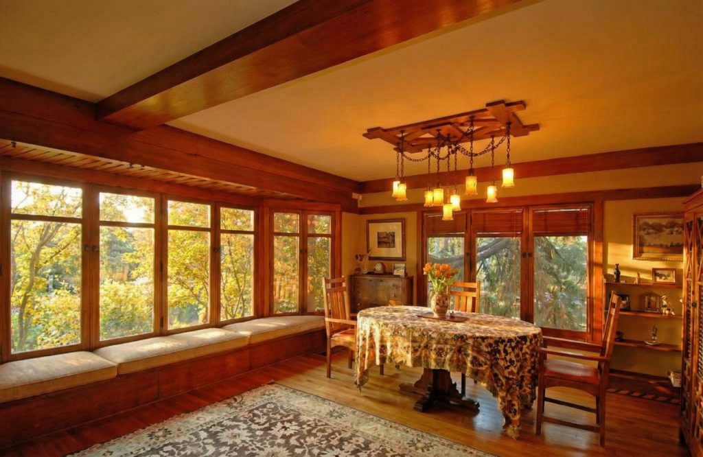 A cozy window seat in dining room of The Caroline S. de Forest House, with wood paneling and a view of the lush greenery outside.