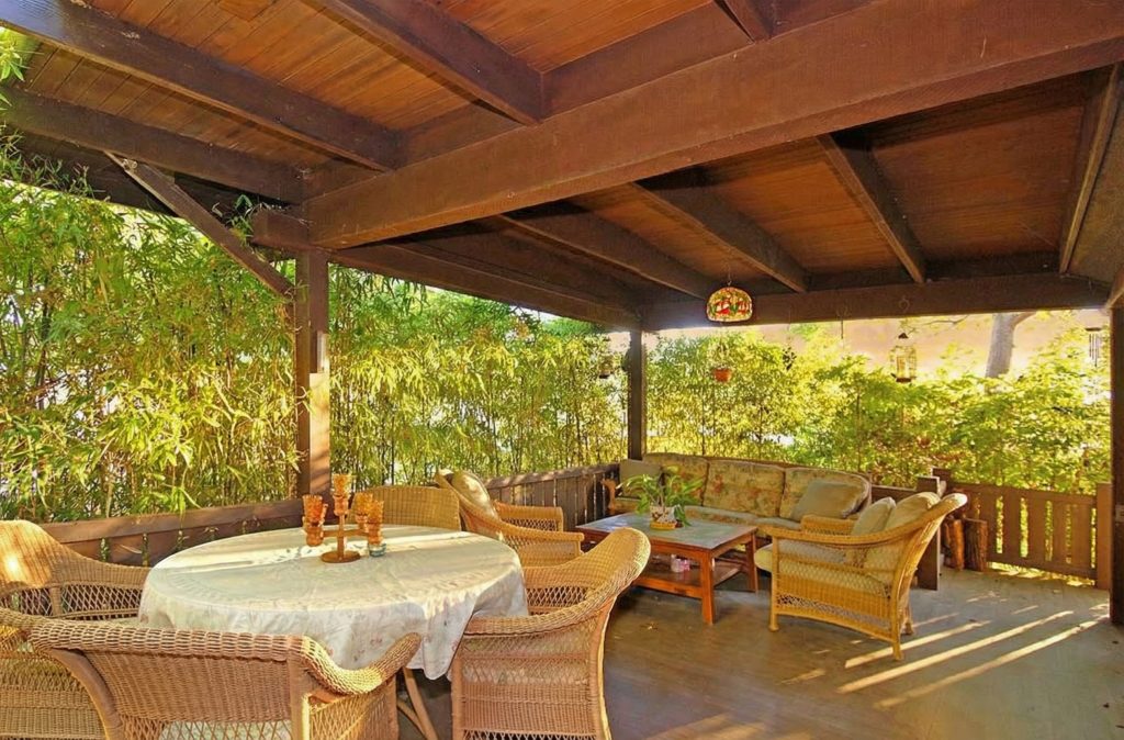 An alternate view of the deck at The Caroline S. de Forest House, showing the connection to the sunroom and the natural landscape.