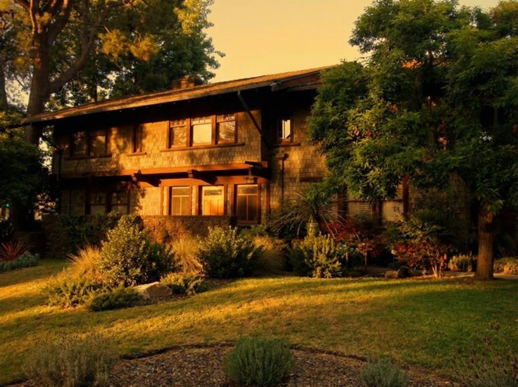 Sidewalk view of The Mary L. Ranney House front facade framed by mature landscaping on Arroyo Terrace.