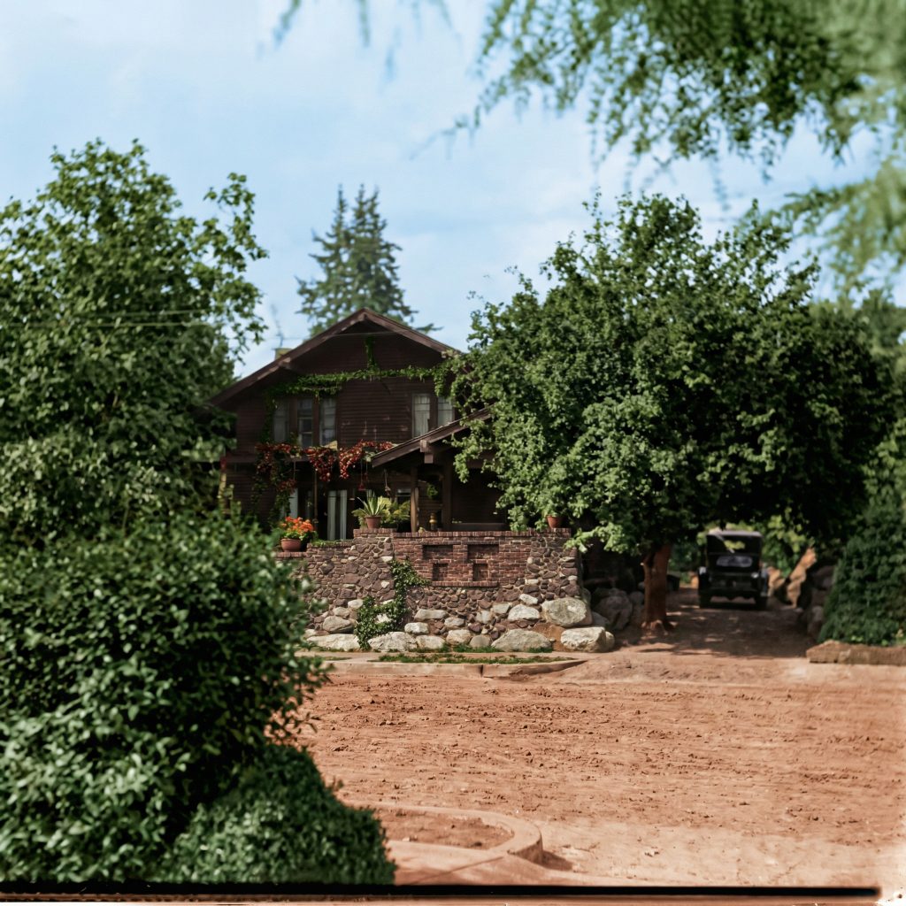 Historic view of the van Rossem-Neil House nestled among lush greenery, with its distinctive stone and brick terrace wall.