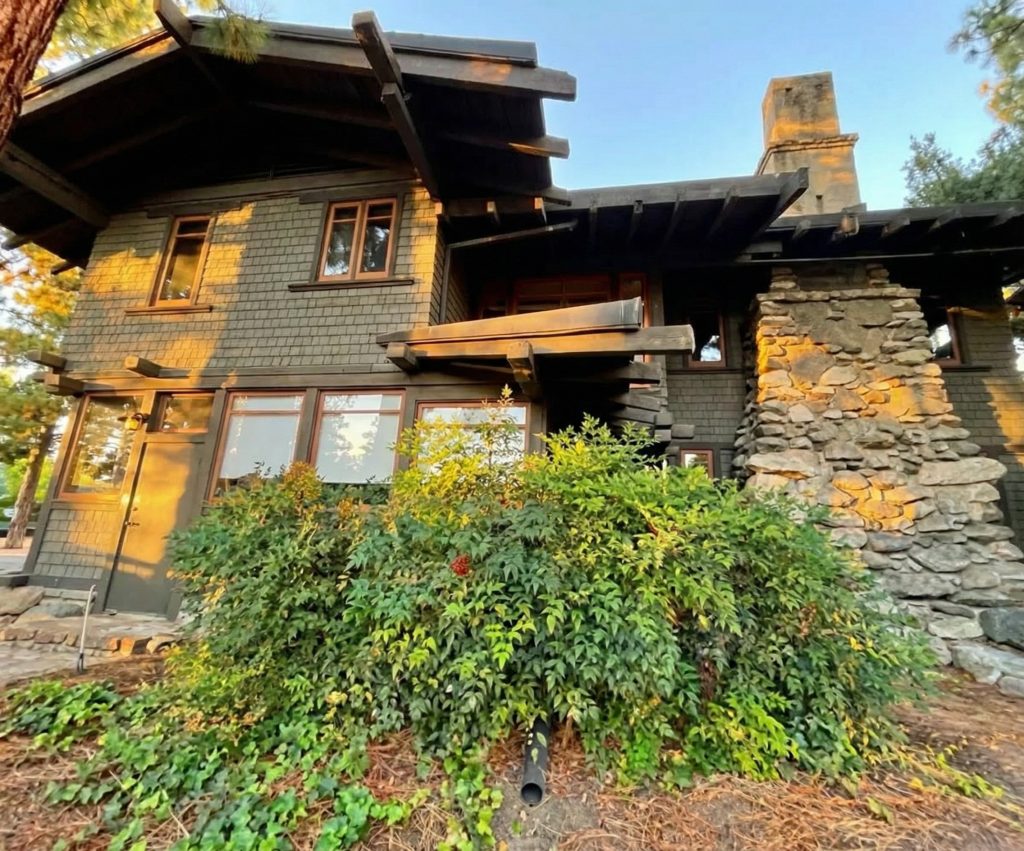 Architectural detail of the north facade of The Mary E. Cole House featuring wood shingles and windows
