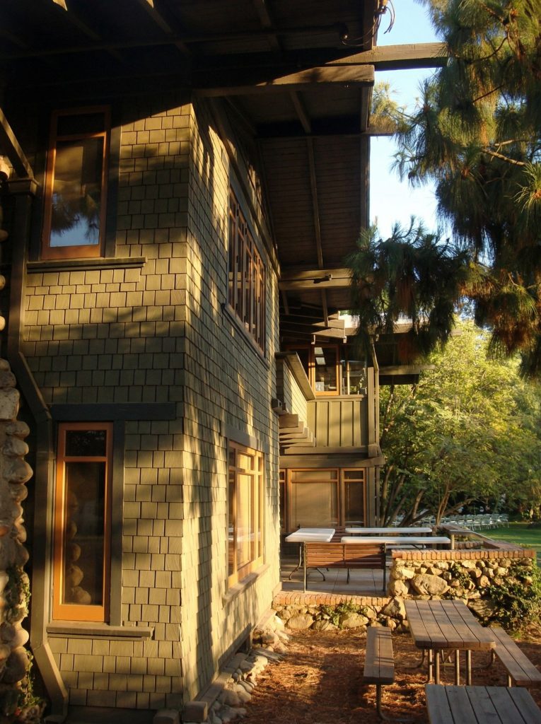 Northwest corner view of The Mary E. Cole House showcasing the layered rooflines and boulder chimney