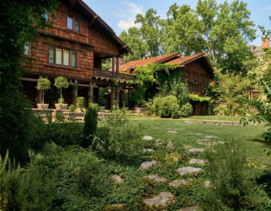 Historic south elevation of Thorsen House with timber pergola, terraced garden, and Greene & Greene craftsmanship