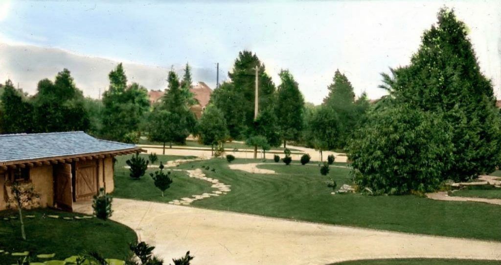 Colorized photograph showing the driveway and garage of the Freeman A. Ford House.