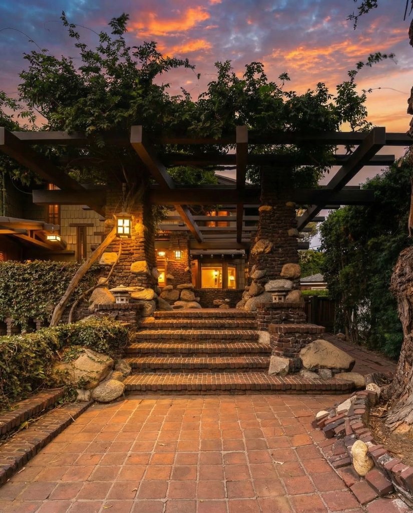 Twilight view of The Duncan-Irwin House front walkway illuminated by handmade copper lanterns.