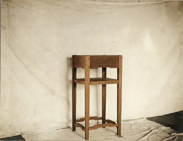 Mahogany lamp stand with ebony pegs and lower shelf from the Mrs. Belle Barlow Bush furniture by Greene & Greene