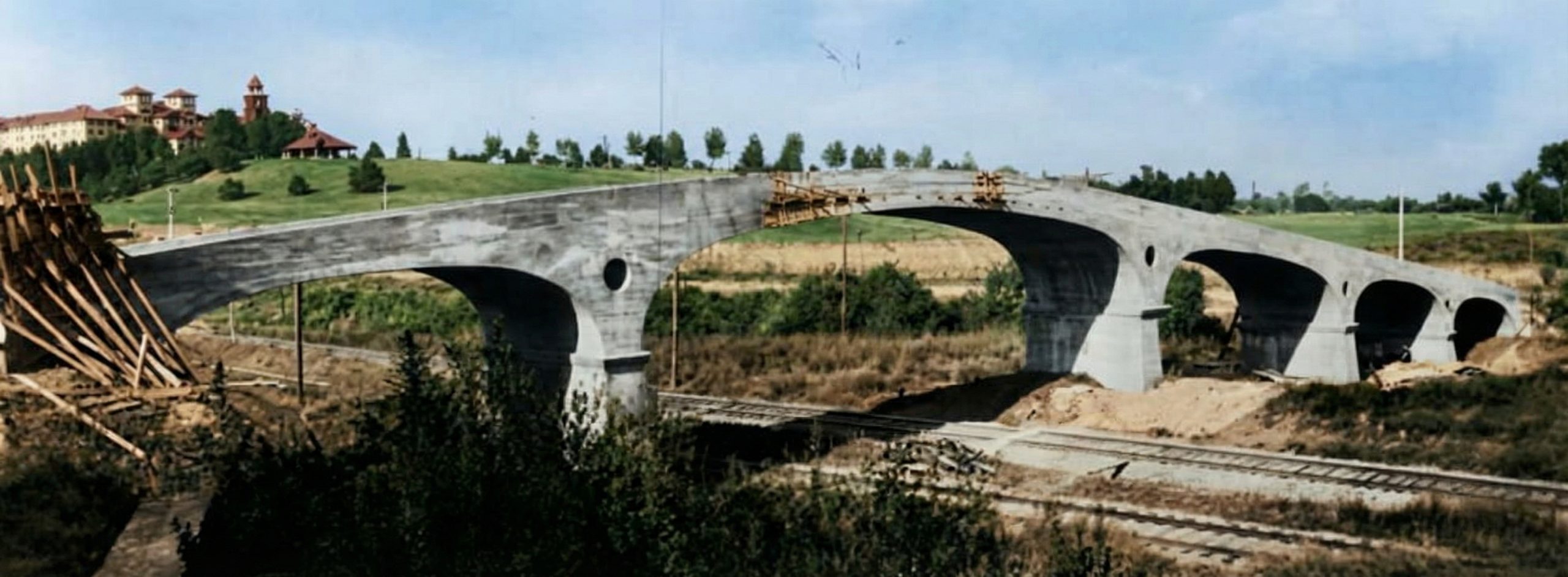 Historical photograph of the Oaklawn Bridge under construction, showing formwork and the partially completed concrete spans