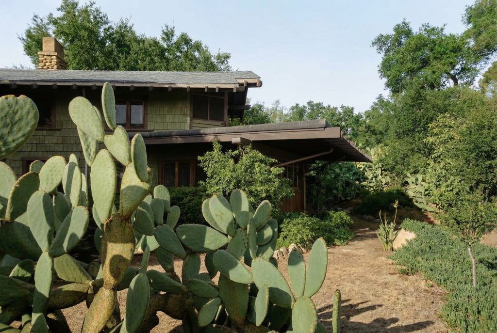 Colorized cactus garden view at The Charles M. Pratt House with desert plantings, stone walls, and architectural backdrop