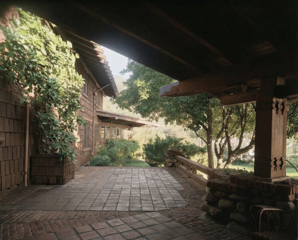 Alternate colorized rear terrace of The Charles M. Pratt House with stone paving, columns, and surrounding gardens