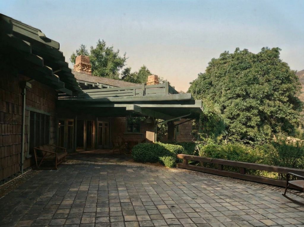 Alternate colorized rear terrace view of The Charles M. Pratt House showing stone columns, paving, and garden landscape