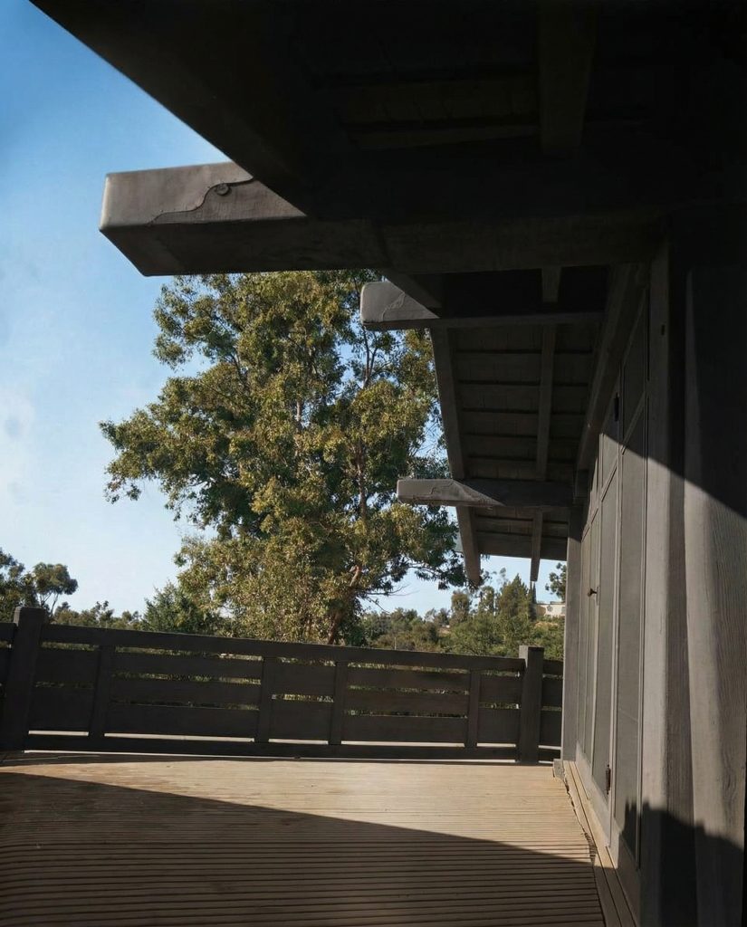 Alternate colorized second floor terrace of The Charles M. Pratt House with wood railings, columns, and garden views