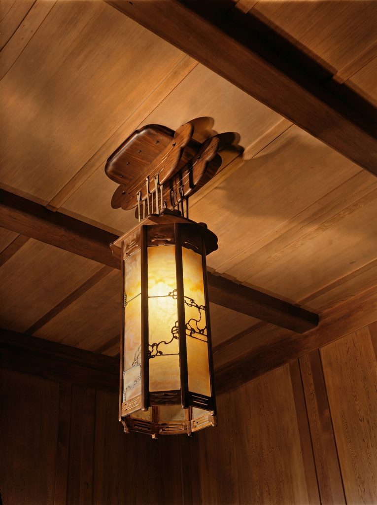 Colorized dining room light fixture of The Charles M. Pratt House with Arts and Crafts design and decorative details