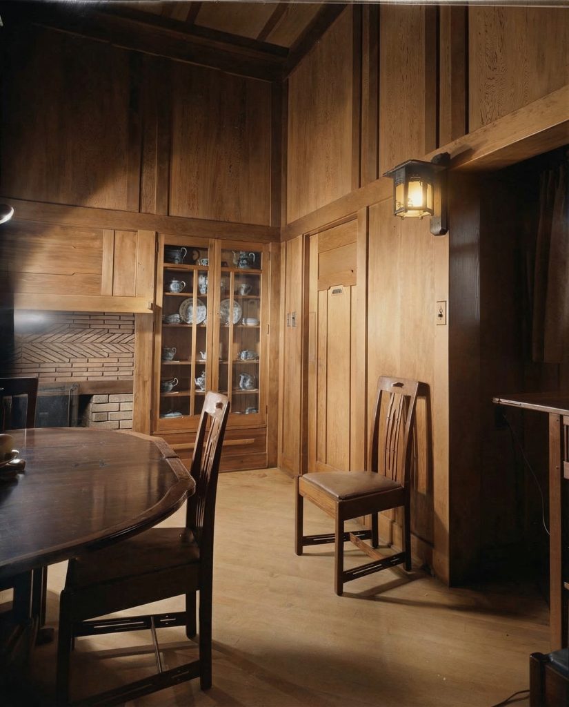 Colorized dining room wall and table of The Charles M. Pratt House showing wood paneling, built-ins, and furnishings