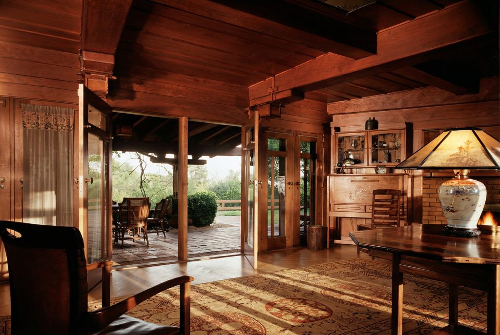 Alternate colorized living room of The Charles M. Pratt House with fireplace, wood paneling, and Arts and Crafts furnishings