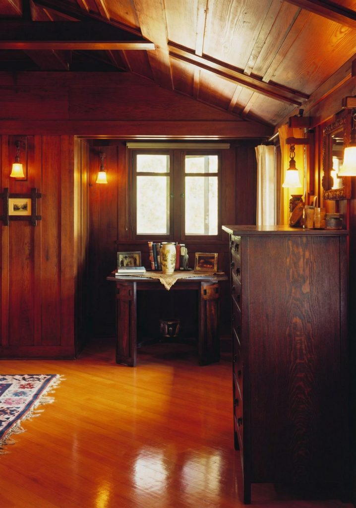 First bedroom corner of The Charles M. Pratt House with wood floors, built-in cabinetry, windows, and period details