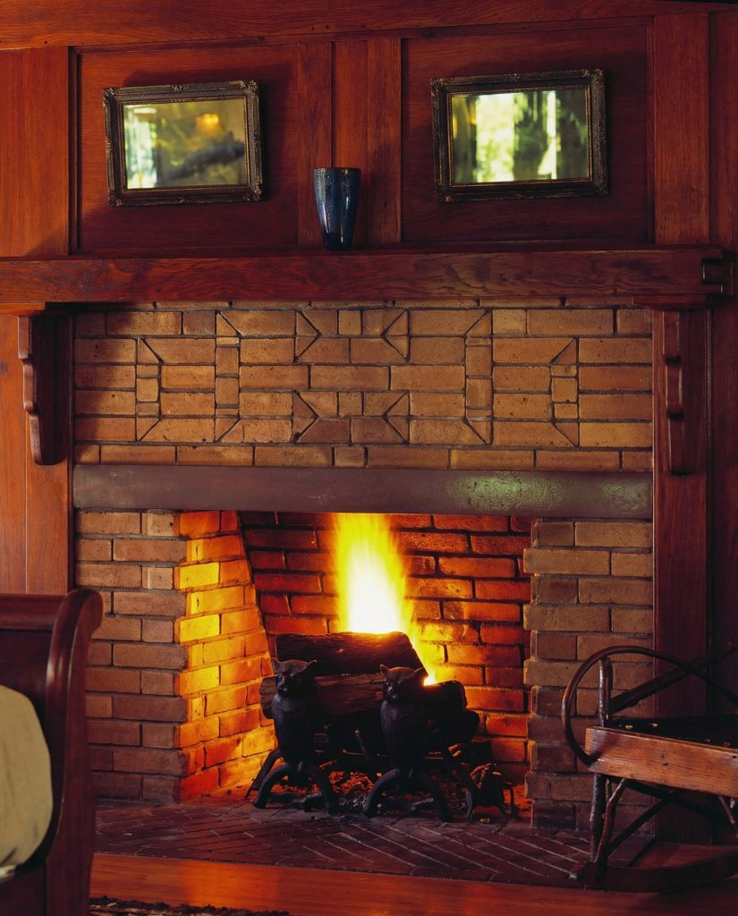 First bedroom fireplace at The Charles M. Pratt House with tile surround, wood mantel, and Arts and Crafts detailing