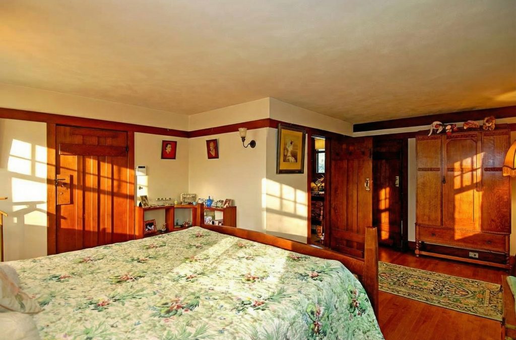 Another bedroom in The Caroline S. de Forest House, featuring a cozy design with a built-in window seat and Arroyo views.