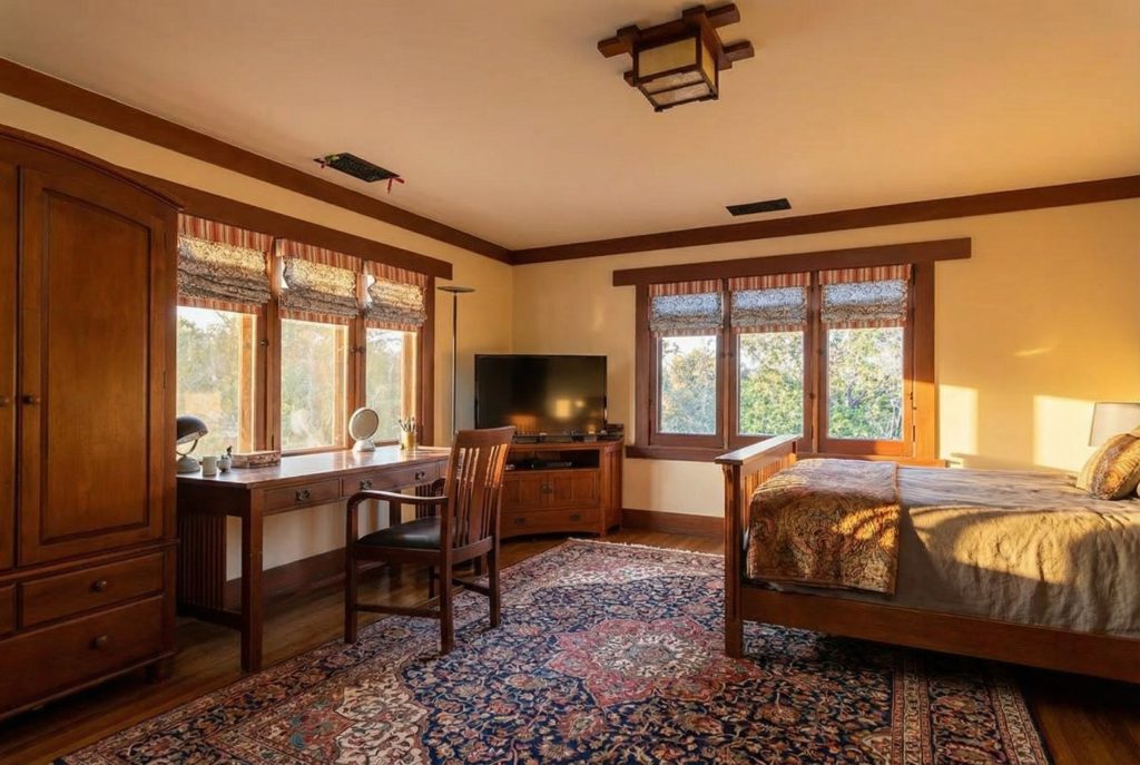 Serene bedroom with fine wood trim and casement windows at The Margaret B. S. Clapham Spinks House.