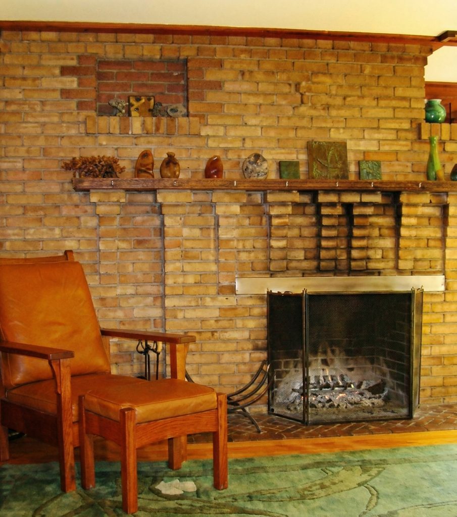 Second bedroom fireplace at The Charles M. Pratt House with decorative tile surround, wood mantel, and built-in seating