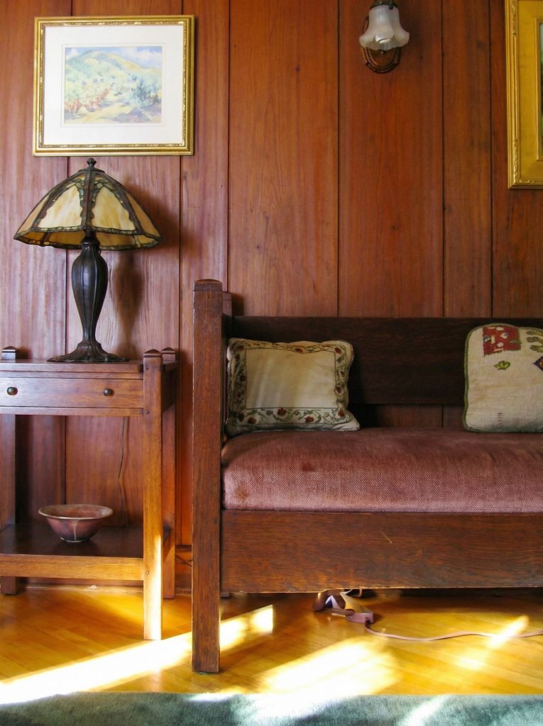 Second bedroom sitting area of The Charles M. Pratt House with fireplace, built-in seating, windows, and wood details