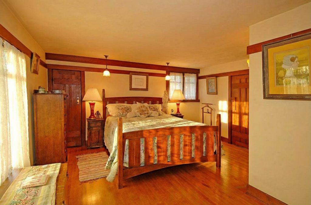 A third bedroom in The Caroline S. de Forest House, showcasing the simple elegance and warm wood tones of the interior design.