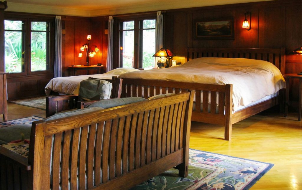 Third bedroom of The Charles M. Pratt House with hardwood floors, built-in cabinetry, fireplace, and sleeping porch access