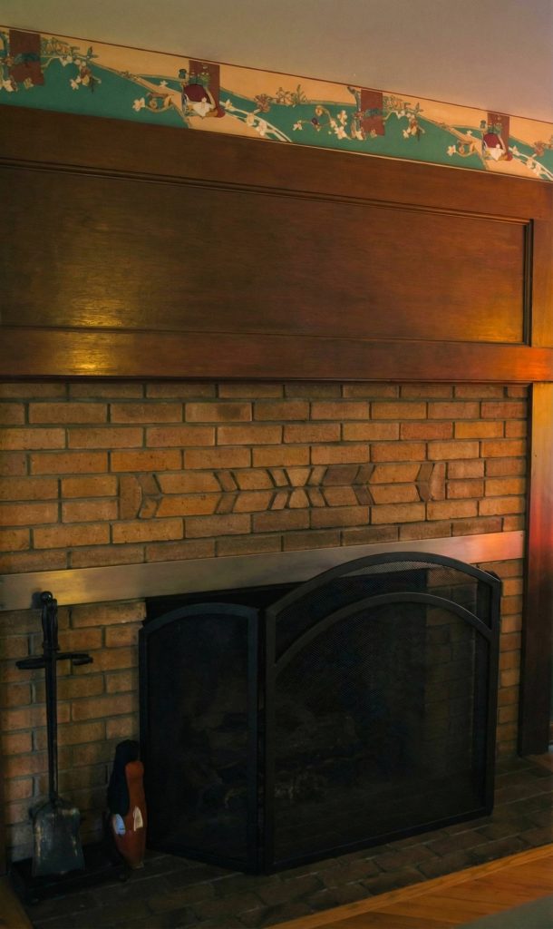 Fourth bedroom fireplace at The Charles M. Pratt House with tile surround, wood mantel, and Arts and Crafts detailing