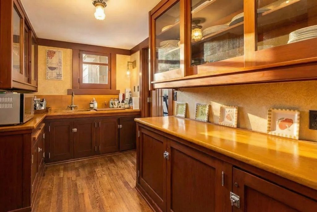 Original butler's pantry with glass-fronted wooden cabinetry at The Margaret B. S. Clapham Spinks House.