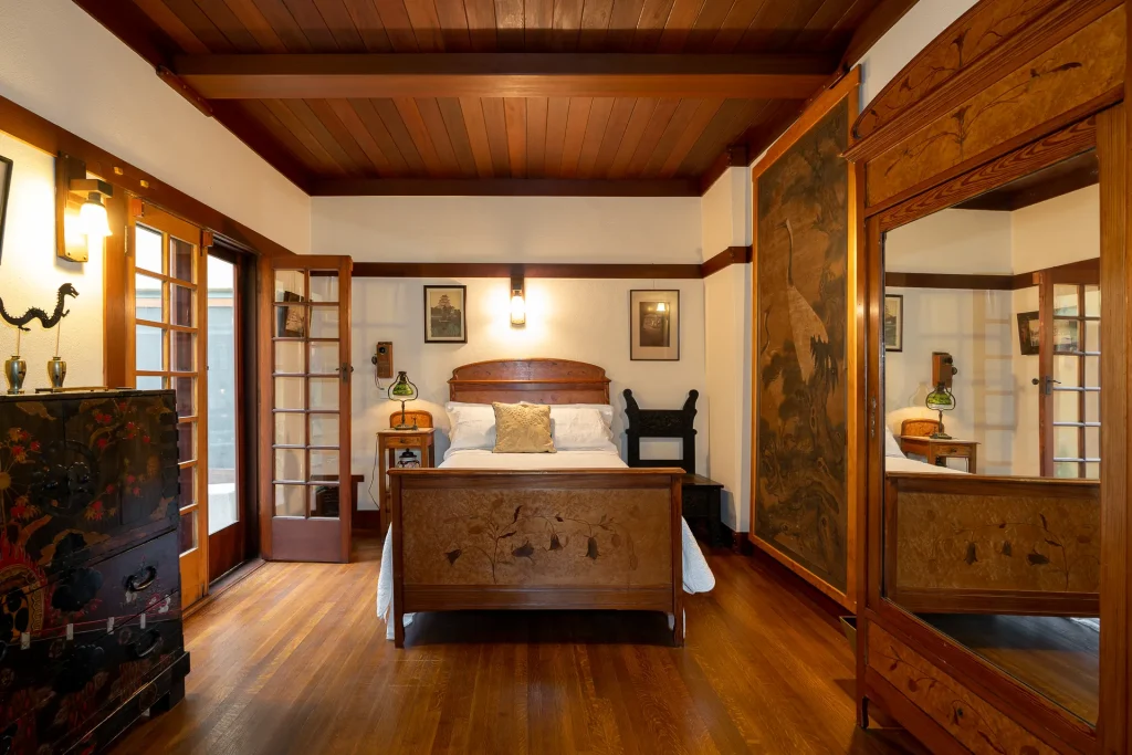 First-floor bedroom of The Duncan-Irwin House with period furnishings and craftsman architectural details.