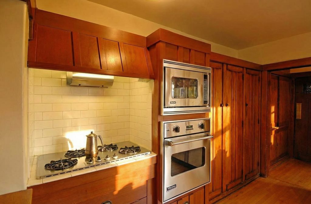 The kitchen of The Caroline S. de Forest House, with its original wooden cabinetry, countertops, and efficient, elegant design.