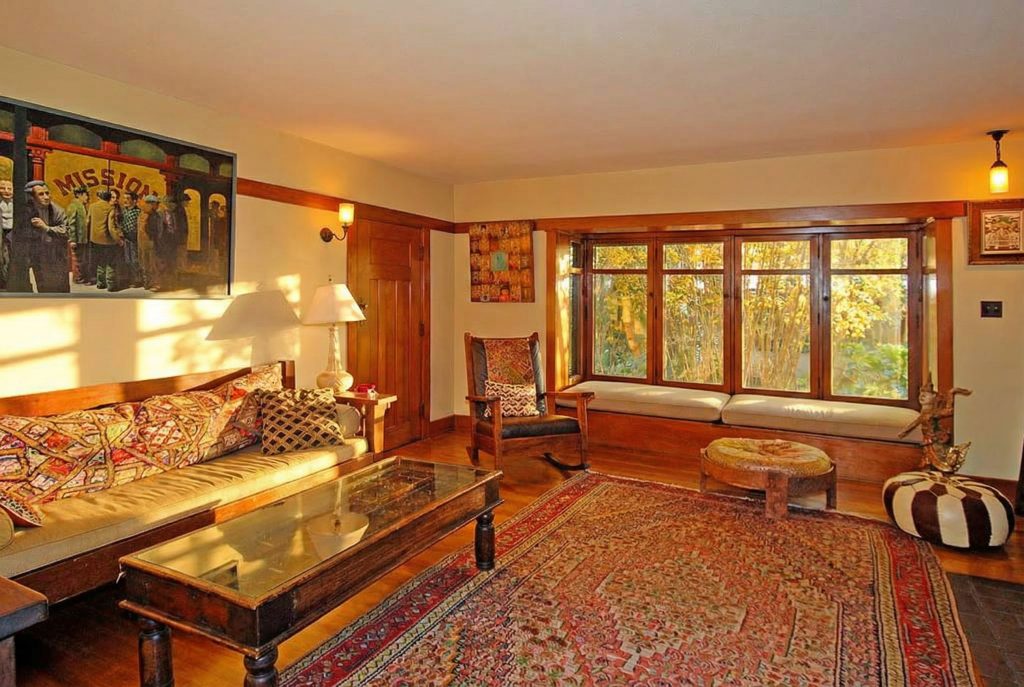 A bedroom in The Caroline S. de Forest House, featuring a clinker brick fireplace, built-in benches, and warm wood paneling.