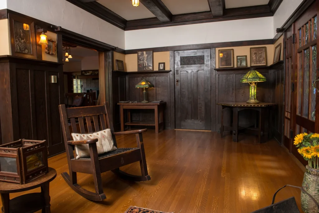 Alternate view of The Duncan-Irwin House living room showcasing beamed ceiling and craftsman joinery.