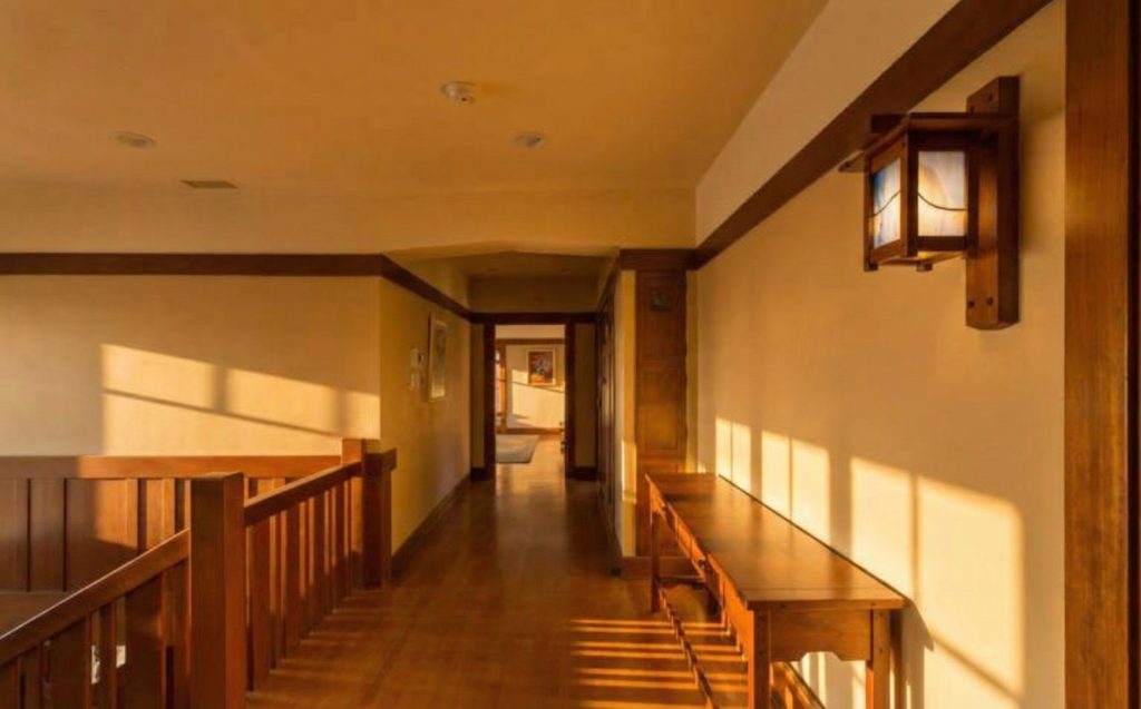 Second floor hallway at The Dr. William T. Bolton House #3 featuring exposed beams and built-in seating.