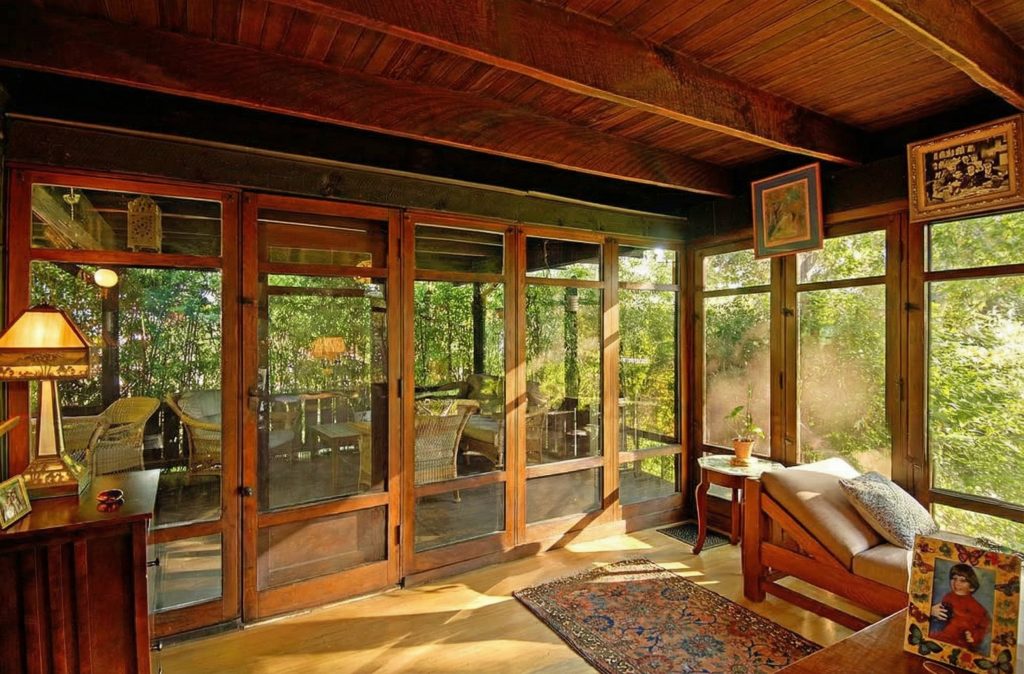 The sunroom of The Caroline S. de Forest House, with its wall of windows overlooking the Arroyo Seco and its rustic, informal feel.