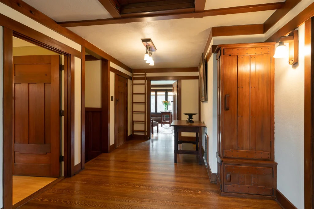Upstairs hallway of The Duncan-Irwin House with wood paneling and access to bedroom suites.