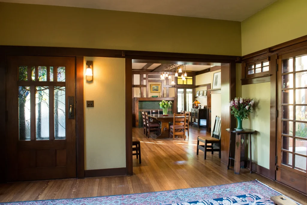 View into The Duncan-Irwin House dining room through craftsman doorway with authentic period furnishings.