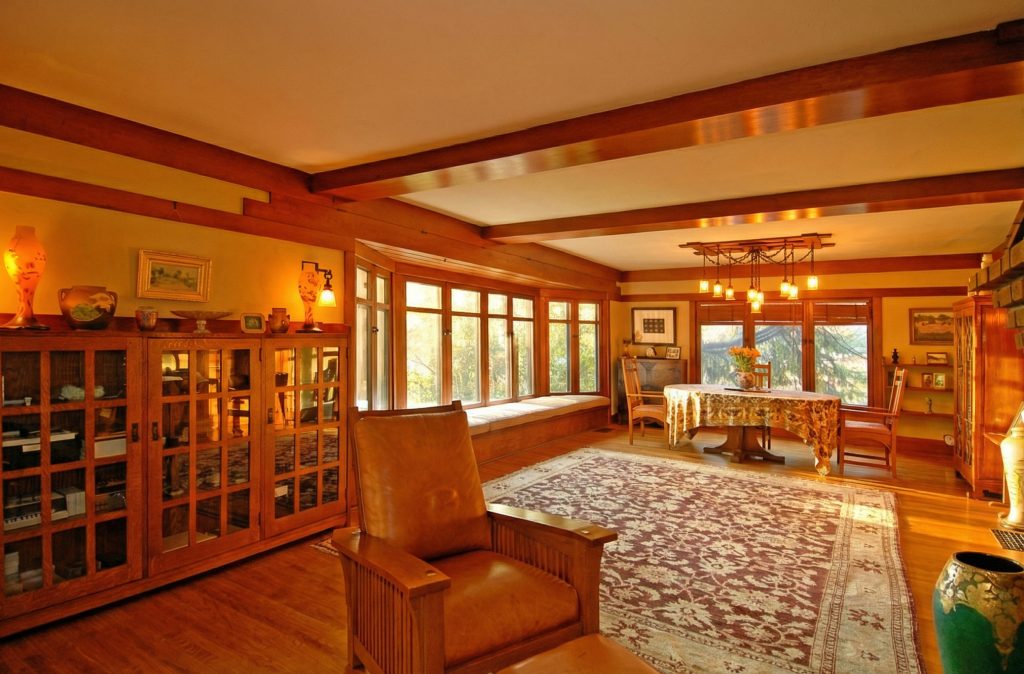 An expanded view of the living room in The Caroline S. de Forest House, showing the long window seat and dining area.