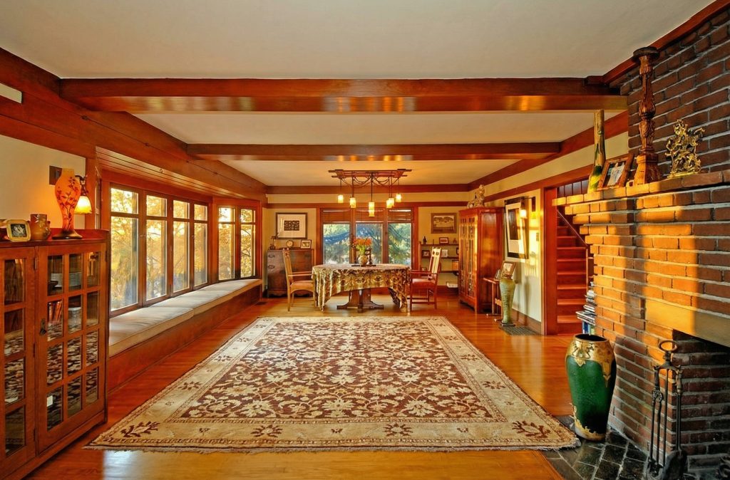 The open plan living and dining area of The Caroline S. de Forest House, with its exposed beams and large Persian rug.