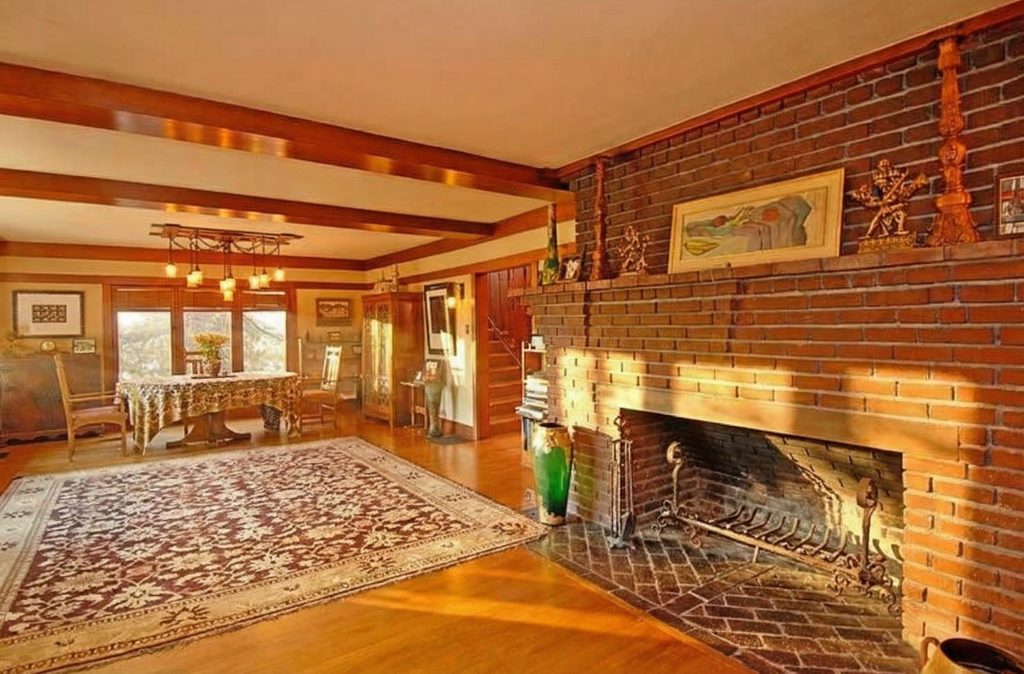 An angled view of the fireplace and living area in The Caroline S. de Forest House, highlighting the warm, inviting atmosphere.