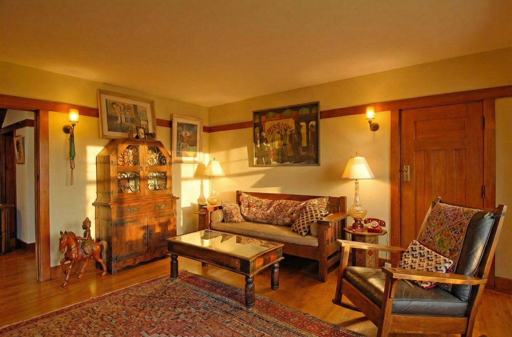 A cozy sitting area in a bedroom of The Caroline S. de Forest House, with period-appropriate furniture and warm lighting.