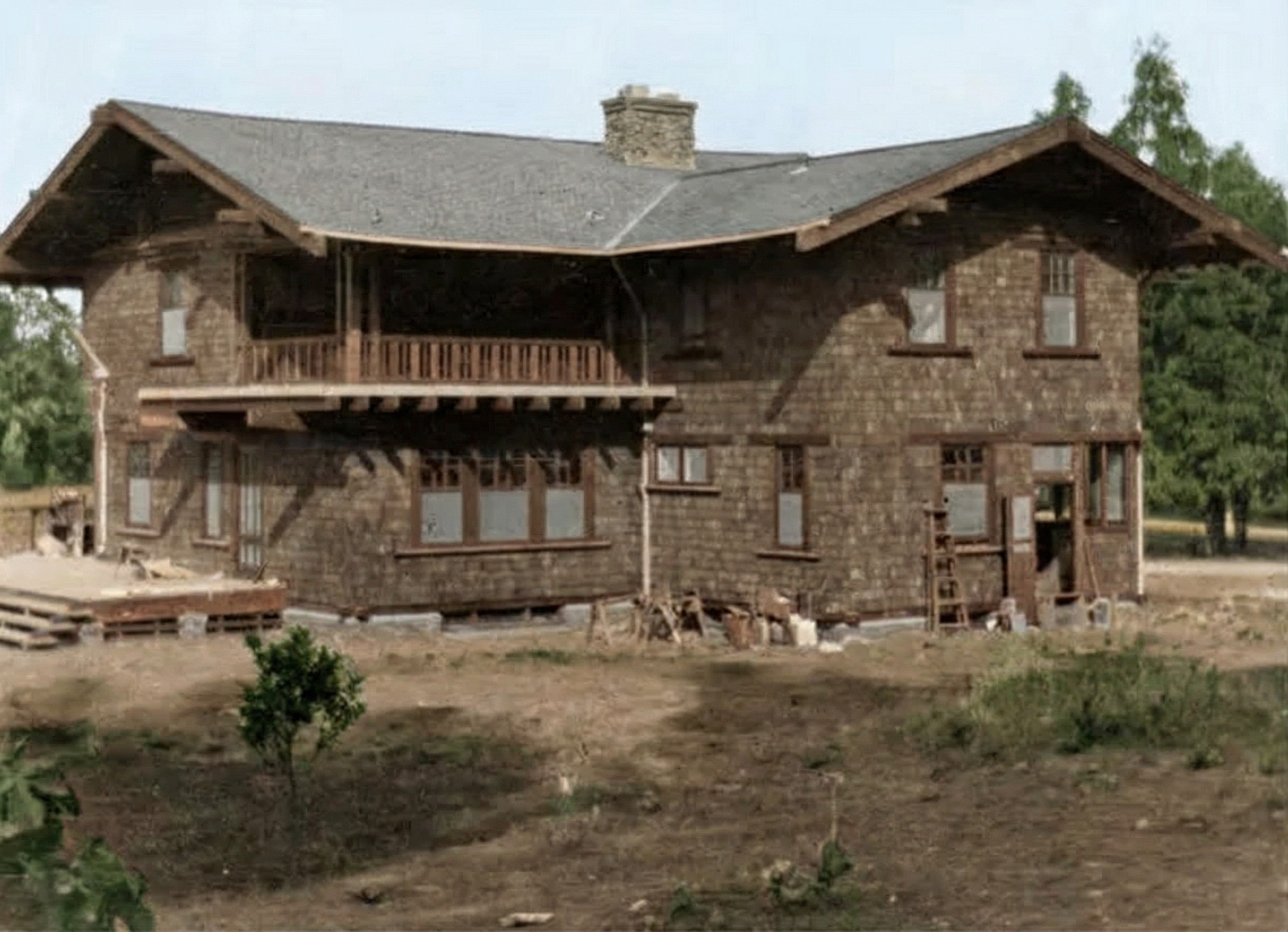 Colorized photograph of the Mary L. Ranney House under construction in 1907, showing the wooden framing, shingle siding, and exposed rafters of the unfinished house