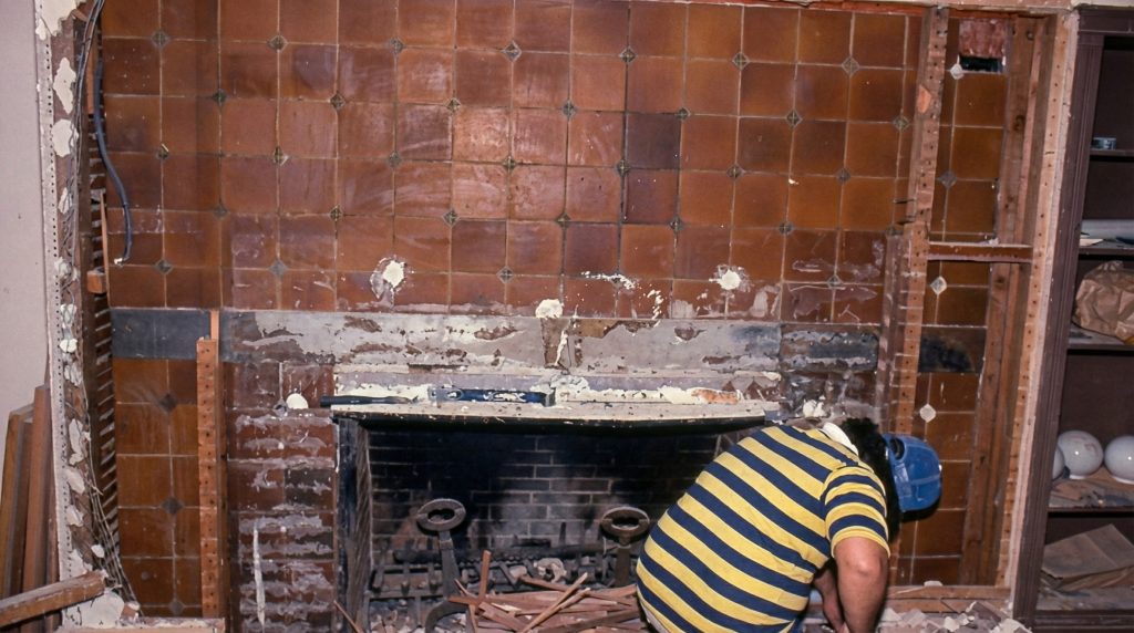 Restoration photograph of the living room fireplace at The Dr. William T. Bolton House #3 showing uncovered tiles.