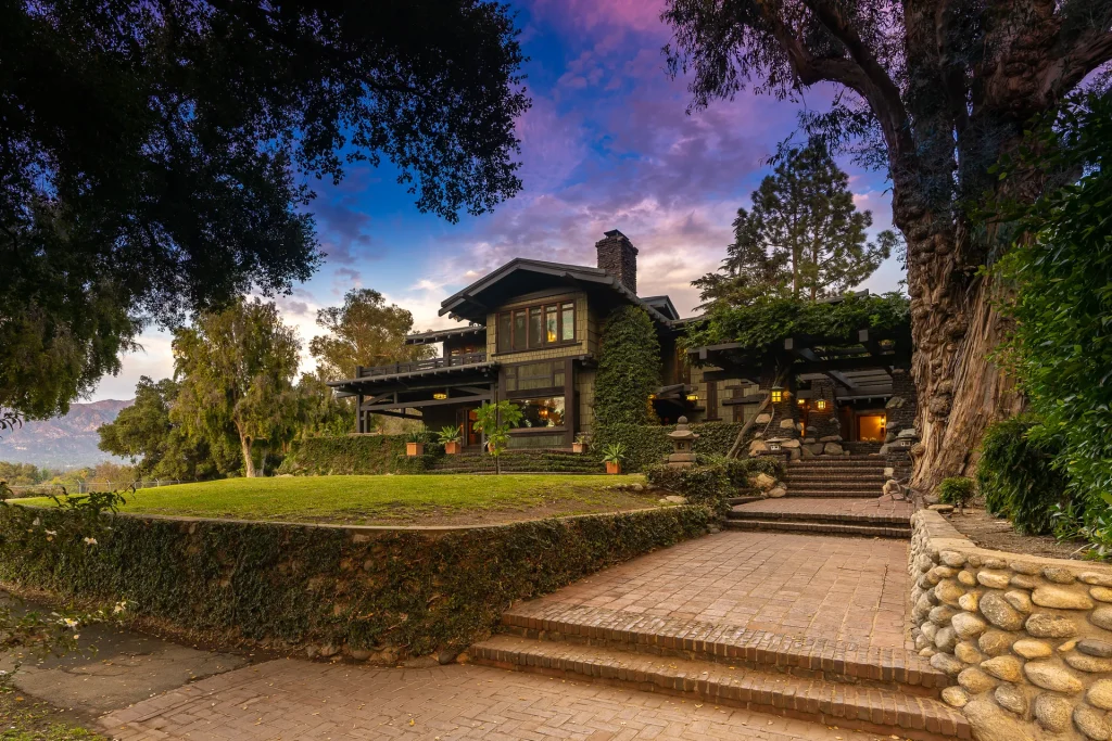 Sidewalk view of The Duncan-Irwin House showing its integration with mature trees and landscaping.