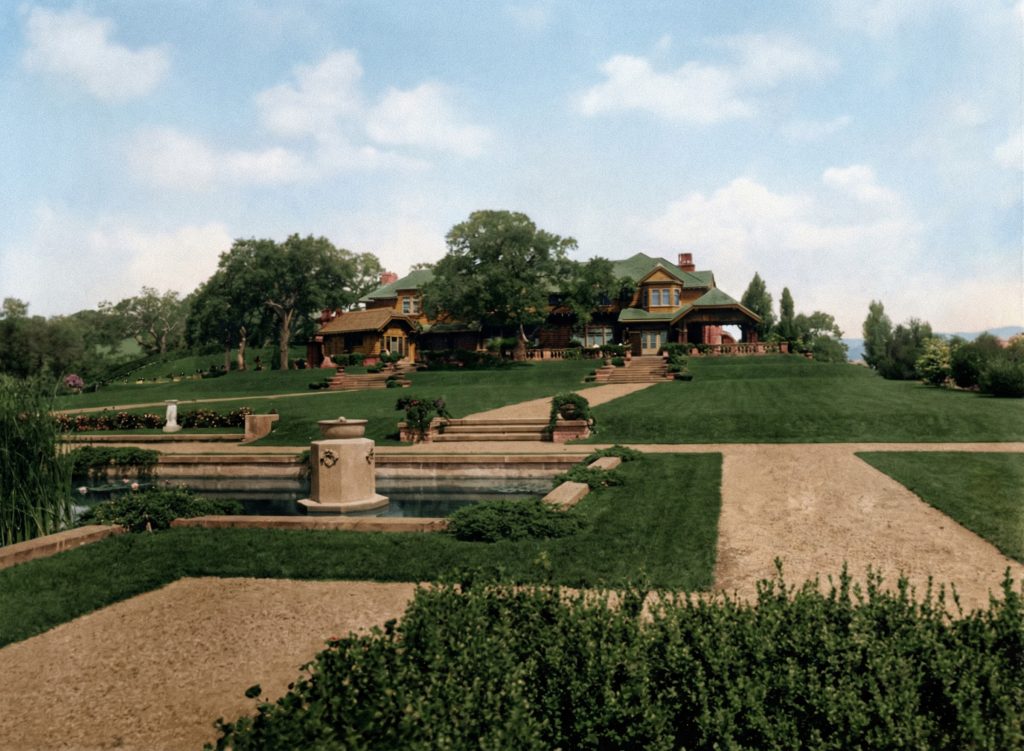 1915 photo of the south elevation and new formal gardens of The Mortimer Fleishhacker Estate, showing the young landscape.